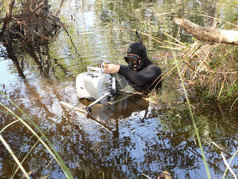 un cameraman filme au ras de l'eau